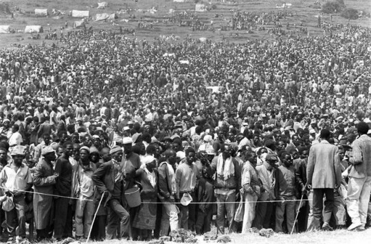 En apenas 48 horas, las ciudades fronterizas zaireñas de Goma y Bukavu vieron llegar a 1,2 millones de refugiados ruandeses, que vivían en miserables condiciones, lo que pronto causó que se registrasen brotes de cólera, disentería, meningitis y otras enfermedades. En la imagen, miles de ruandeses esperando recibir alguna ayuda de los organismos internacionales en los campos para refugiados de la zaireña ciudad de Goma, 29 de junio de 1994. Foto: GERVASIO SÁNCHEZ 