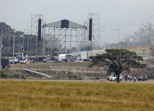 Workers prepare the area for the upcoming "Venezuela Aid Live" concert at the Tienditas International Bridge on the outskirts of Cucuta, Colombia, on the border with Venezuela, Wednesday, Feb. 20, 2019. Billionaire Richard Branson is organizing the concert on Feb. 22 featuring Spanish-French singer Manu Chao, Mexican band Mana, Spanish singer-songwriter Alejandro Sanz and Dominican artist Juan Luis Guerra, Colombian singers Juanes and Carlos Vives among others. (AP Photo/Fernando Vergara)