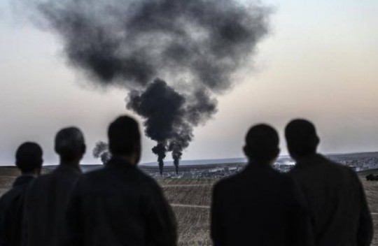 Sirios observan explosiones en la ciudad de Kobane luego de que se intentara instalar un gobierno paralelo en su país. (Foto: AFP)