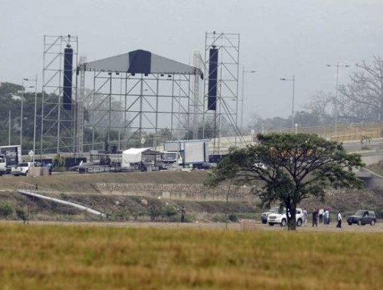 Workers prepare the area for the upcoming "Venezuela Aid Live" concert at the Tienditas International Bridge on the outskirts of Cucuta, Colombia, on the border with Venezuela, Wednesday, Feb. 20, 2019. Billionaire Richard Branson is organizing the concert on Feb. 22 featuring Spanish-French singer Manu Chao, Mexican band Mana, Spanish singer-songwriter Alejandro Sanz and Dominican artist Juan Luis Guerra, Colombian singers Juanes and Carlos Vives among others. (AP Photo/Fernando Vergara)
